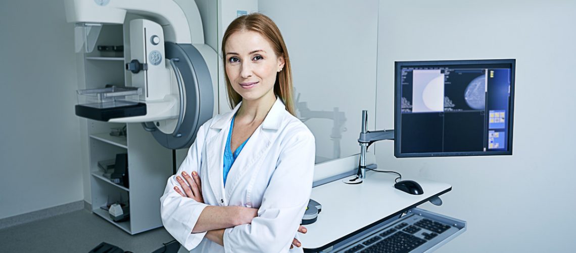 Experienced female radiologist standing near mammography workstation at radiology room of hospital. Mammography, mammogram