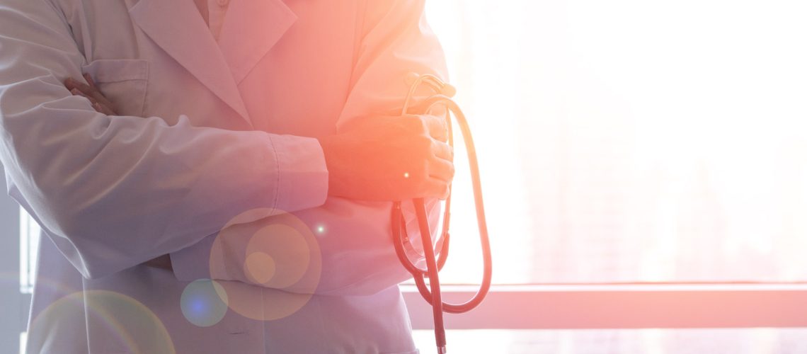 Professional medical physician doctor in white uniform gown coat hand holding stethoscope in clinic hospital.Medical/ healthcare/ technology concept